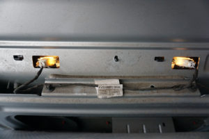 Die Rückansicht der eingebauten Kennzeichenleuchte mit zwei funktionierenden Lampen. Die Verkleidung der Heckklappe ist für die Aufnahme zurückgeklappt.